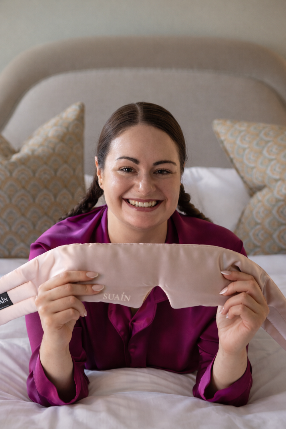 Woman wearing a white Still Suain silk sleep mask and white sleepwear